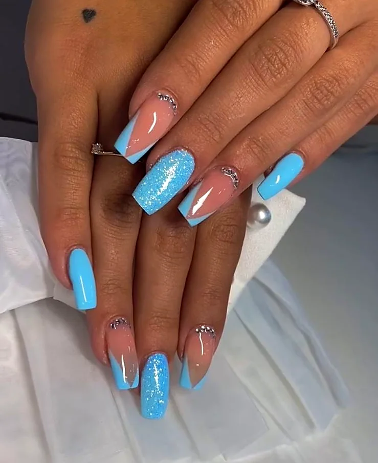 Unghie azzurre con French a V, glitter e punti luce